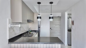 A modern kitchen with a central island, stainless steel appliances, and pendant lighting. - Cozy apartment, location to enjoy the beautiful Cartagena/Colombia. (Cartagena de Indias)