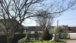 Een geplaveid pad naar een gebouw met een tuin en een standbeeld.