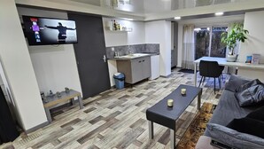 Een ruimtelijke leefruimte met keuken, eethoek en zithoek.