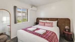Una camera da letto con un letto, un comodino, una lampada, un armadio e una finestra con vista.