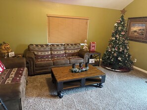 A living room with a brown leather sofa, a wooden coffee table, a Christmas tree, and a framed picture on the wall. - Private 3 -bedroom house in delightful Lake Arrowhead,  with AC comfort (Lake Arrowhead)