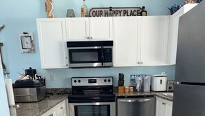 A kitchen with white cabinets, stainless steel appliances, a microwave, oven, toaster, and a refrigerator. - Fully Furnished 2BR/2BA Bimini Bay Condo (Bimini)