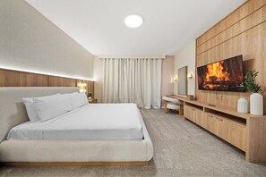 A modern bedroom with a large bed, a TV mounted on a wooden wall, a desk, and a chair. - 7BR house with private pool in Solara Resort (Kissimmee)