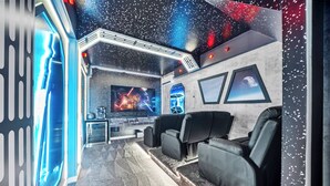 Un home theater con un grande schermo, poltrone reclinabili e un pavimento in moquette.