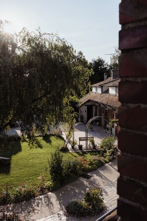 Ein Innenhof mit einem Haus, einer Ziegelmauer und einem Garten.