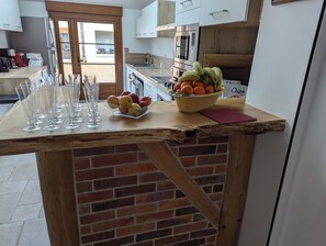 Eine Küchenarbeitsplatte mit Obstschale, Gläsern und einer Tüte Chips.