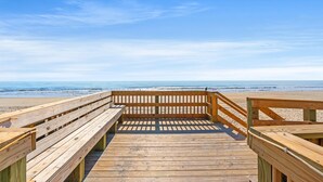 A wooden boardwalk leading to a beach with a clear sky. - MB RESORT (Myrtle Beach)
