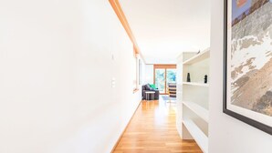A modern interior with a wooden floor, white walls, and a framed picture on the wall.