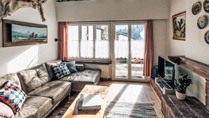 A living room with a sofa, coffee table, fireplace, and a large window.