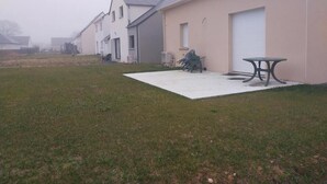A residential building with a flat roof, a covered patio, and a table. - New 3-bedroom bungalow (Mouzeil)