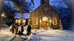 A stone church with a bell tower, a wooden door, and a snow-covered ground. - Cedar - Big Moose Lakeside (Eagle Bay)