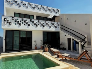 Ein modernes, zweistöckiges Gebäude mit Swimmingpool, Außenbereich und Treppe.