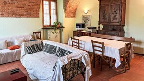 Une pièce chaleureuse avec un plafond en briques, un canapé, une table à manger et un buffet.