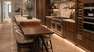 Een moderne keuken met een centraal eiland, houten kastjes en roestvrijstalen apparatuur.