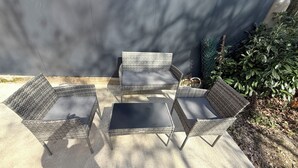 A patio area with wicker furniture and a concrete floor. - La dorée, a private room in an independent apartment (Billère)