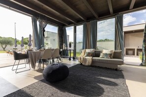 Ein geräumiger Wohnbereich mit einer Couch, Hocker und einem Essbereich.