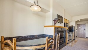 A kitchen with a granite countertop, wooden chairs, a built-in oven, and a microwave. - Chula Vista Resort Studio Villa in Wisconsin Dells! Free Waterpark Passes! (Wisconsin Dells)