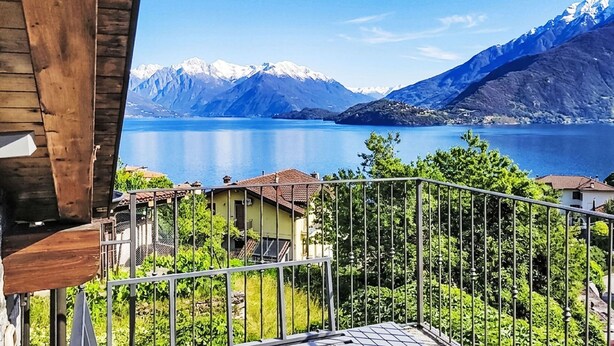 Een balkon met uitzicht op een meer en bergen.