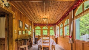 Eine Holzdiele mit Essbereich, Holzwänden und Rundbogenfenstern.