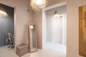 Ein modernes Badezimmer mit einem großen Spiegel, einem Handtuchhalter und einer Sitzbank.