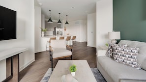 Ein modernes Wohnzimmer mit einer Couch, einem Couchtisch und einem Fernseher.