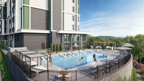 Ein modernes Gebäude mit Pool auf dem Dach, Liegestühlen und einer überdachten Sitzgelegenheit.