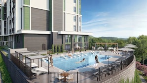 Un edifici modern amb una piscina al terrat, seients de bany i una zona de descans coberta.