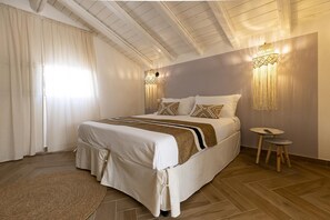 Ein Schlafzimmer mit Bett, Vorhängen, Teppich, einer Wandlampe und einem kleinen Tisch.