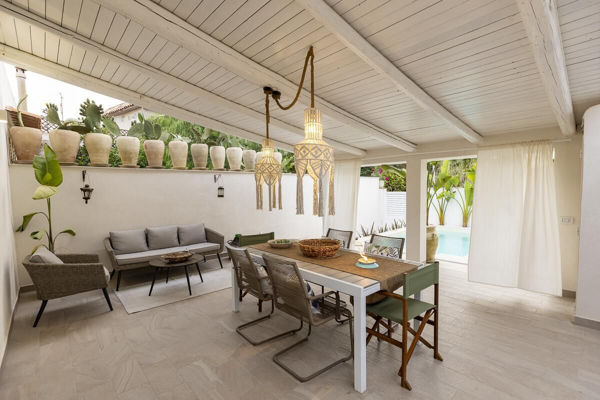 A dining area with a table, chairs, and hanging lights.
