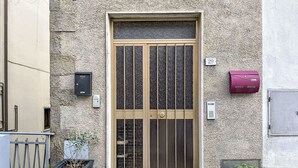 Ein Gebäude mit einer großen, verzierten Tür, einem Briefkasten und einem kleinen Blumenkasten.