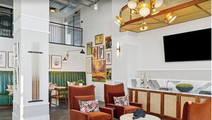 Un interno moderno con zona pranzo, posti a sedere, opere d'arte e televisore.