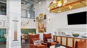 Ein modernes Interieur mit Essbereich, Sitzgelegenheiten, Kunstwerken und einem Fernseher.