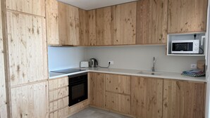 A kitchen with wooden cabinets, a microwave, a toaster, and a dishwasher.