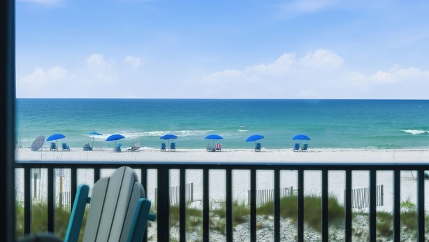 Une plage avec vue sur la mer, des parasols et des chaises longues.