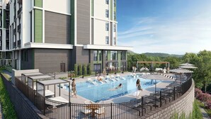 Ein modernes Gebäude mit Pool auf dem Dach, Liegestühlen und einer überdachten Sitzgelegenheit.