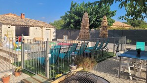 A pool area with chairs and a grill, surrounded by a fence and potted plants. - Peaceful charming house (Lapalud)