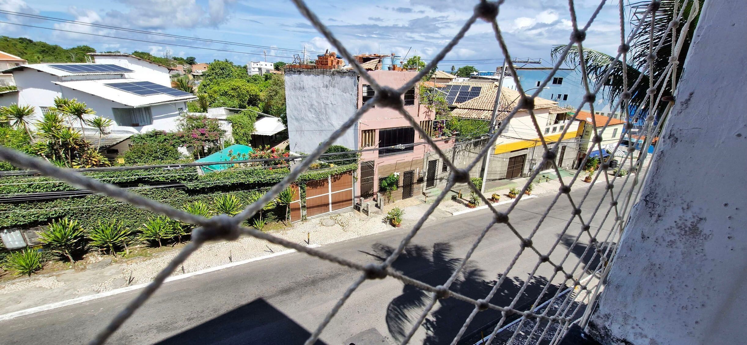 Zona residencial con casas, paneles solares y una calle.