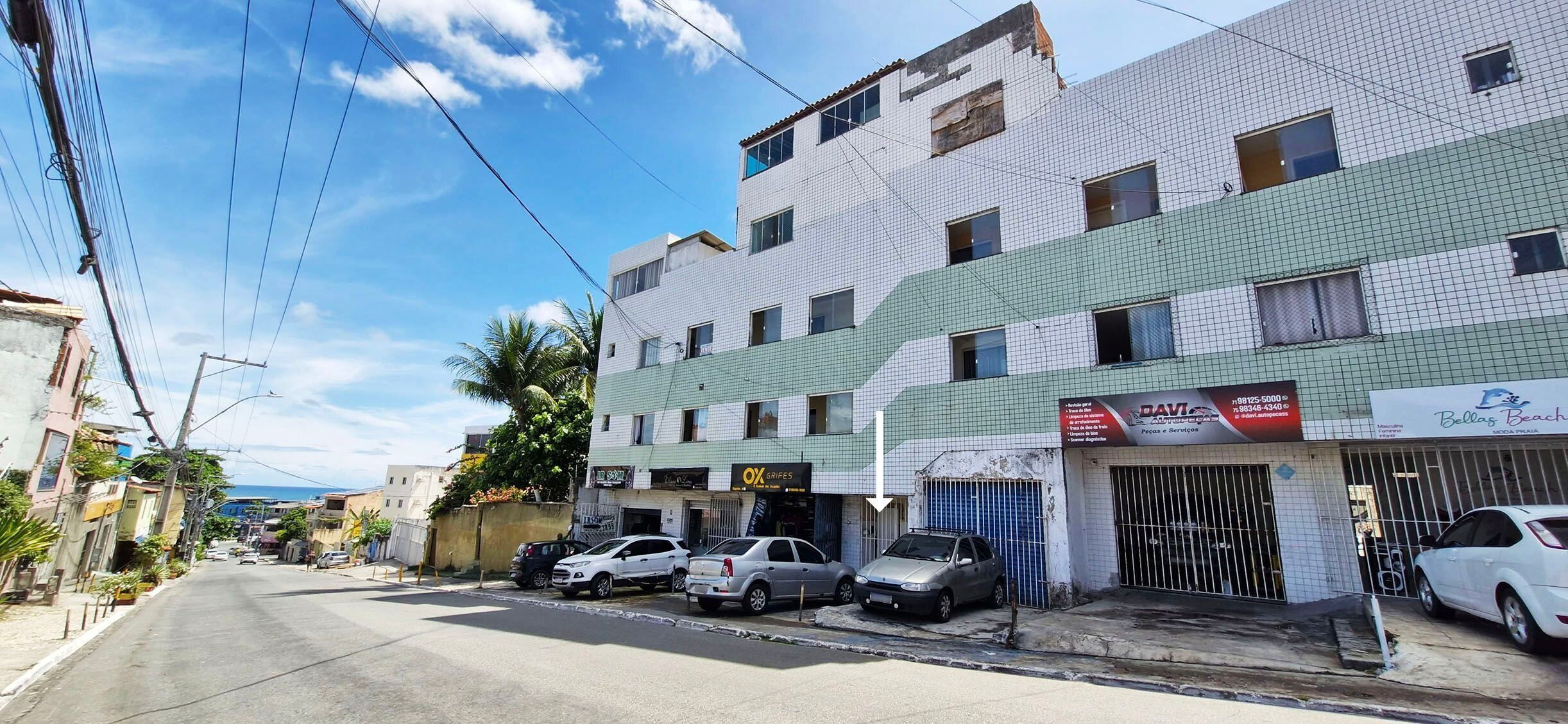 Una calle con edificios, coches aparcados y cielo despejado.