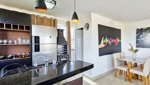 Eine moderne Küche mit einem eingebauten Kühlschrank, einer Spüle und einem Essbereich mit Tisch und Stühlen.