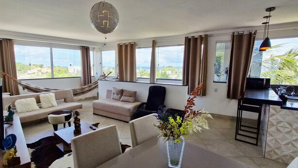 Ein großzügiger Wohnbereich mit Sofa, Esstisch und Blick ins Freie.