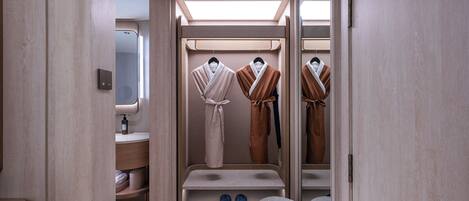 A modern bathroom with a walk-in shower, a vanity with a mirror, and a robe rack.