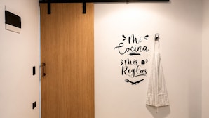 A room with a wooden door, a wall-mounted towel rack, and a decorative wall sign. - Stay 32 (Medellín)