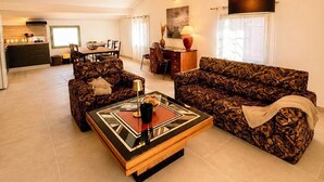 Un salon comprenant un canapé, une table basse et un coin repas avec des chaises et une table.