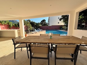 An outdoor patio with a pool, lounge chairs, and a table with chairs. - Résidence ANTONIA - Attic apartment with pool access - Calvi town center (Calvi)