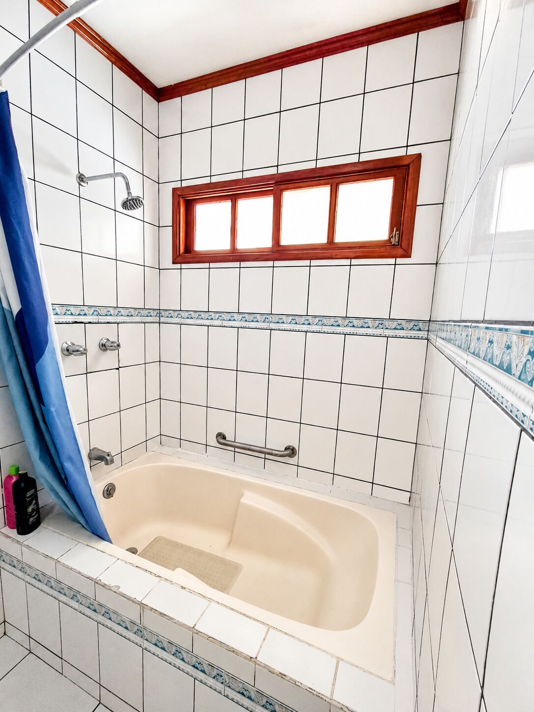 A bathroom with a bathtub, a shower, and a window.