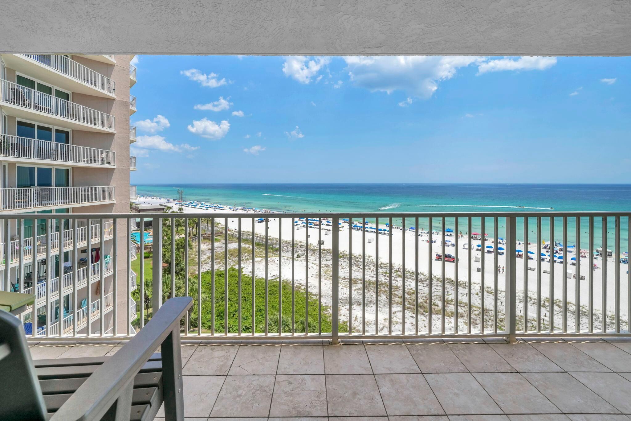 A balcony with a view of a beach and ocean.