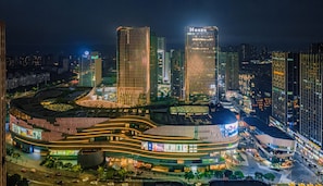 A modern hotel with a curved facade, multiple floors, and a prominent entrance. - Chongqing Jinkai Aegean Crystal HoteL (Chongqing)