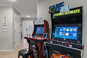 Two arcade machines, a door, and a wall sign. - Bamba's Beach House (Destin)