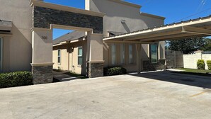 A residential building with a stone facade, a covered driveway, and a gated entrance. - Beautiful Apartment with 4 Beds in Gated Community Close of Shops (McAllen)