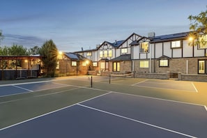 A tennis court with a building in the background.